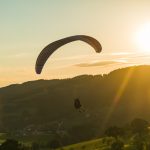 Paraglider landing into the sunset